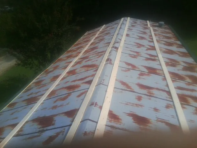 Rusted metal roof panels with new wood purlins before replacement — Storm Damage Roof Repair in Northpoint by Roofing Brothers