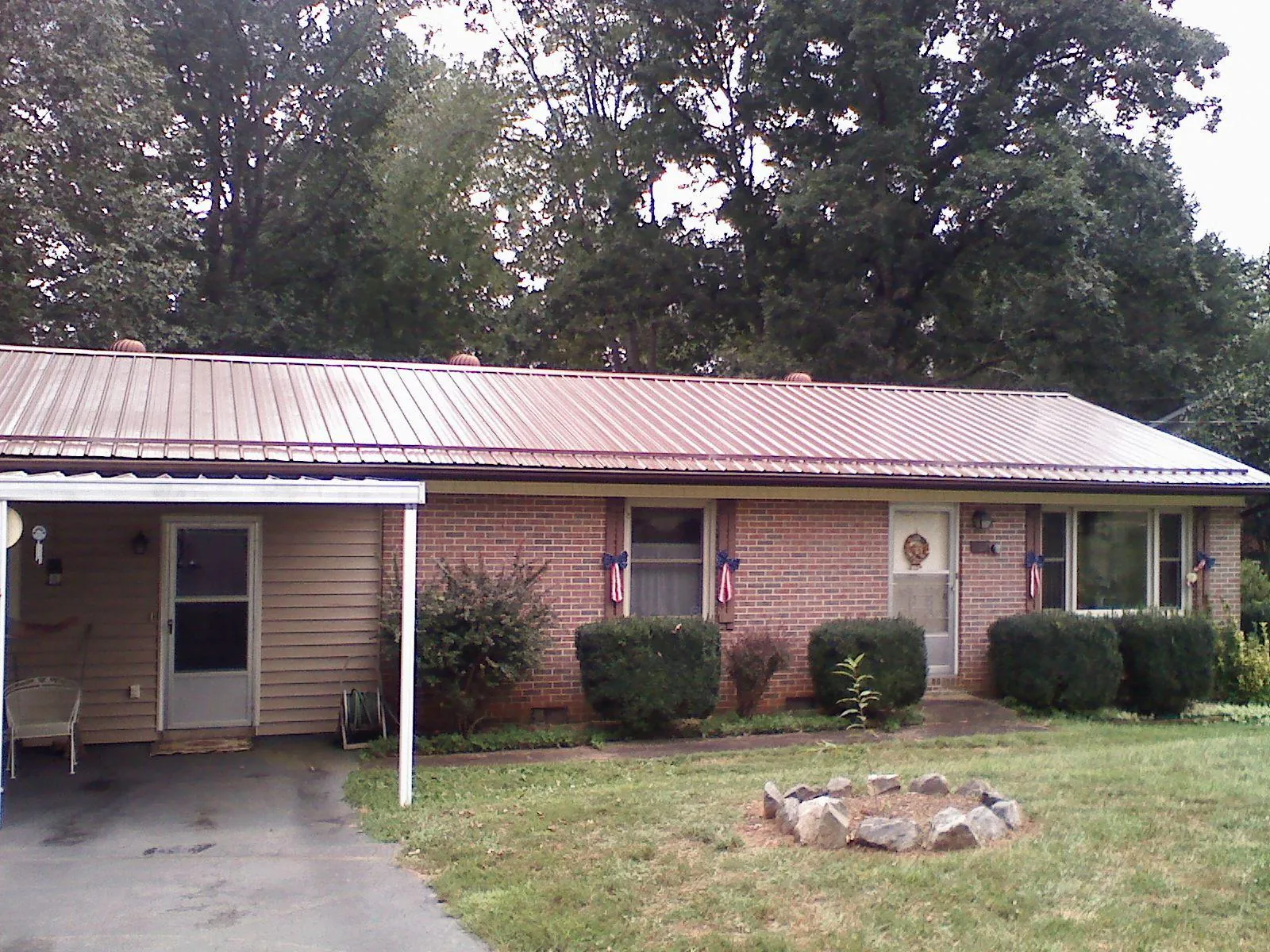 Bronze metal roof and carport on a brick ranch home — Roof Repair work by our crew in Northpoint